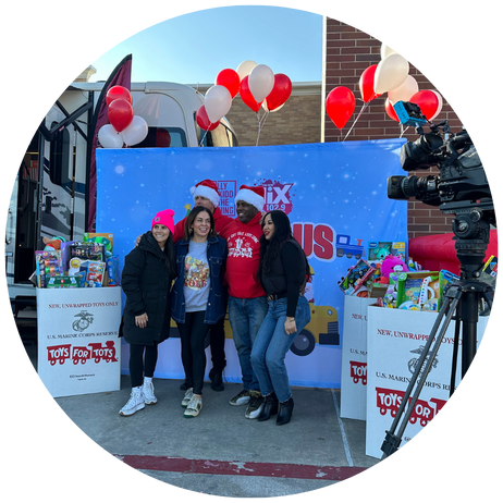 People posing for photos and video at Toys For Tots event